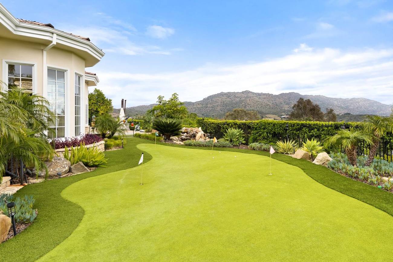 The private putting green at 1403 Kingsboro Court with the Santa Monica Mountains beyond