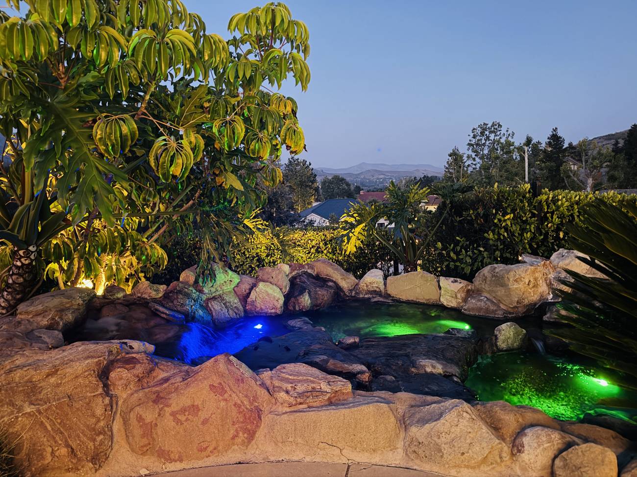 1403 Kingsboro Court, lit rock waterfall and spa with valley views at dusk